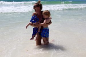 mom holding babies in the waves of the emerald coast, destin