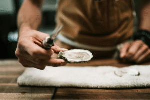 A Personal Chef serving an oyster.